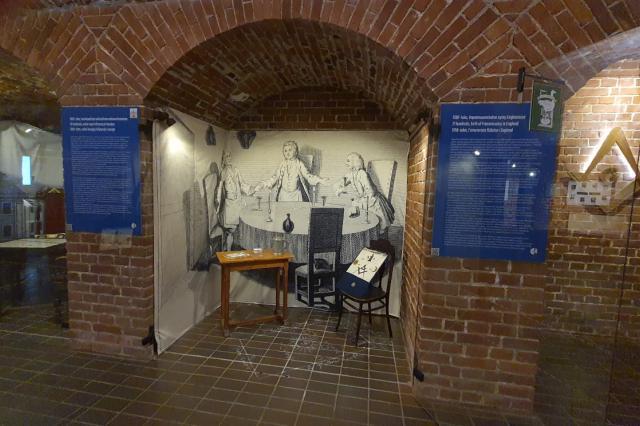 Display case installed under brickwork arches, flanked by two blue interpretation banners