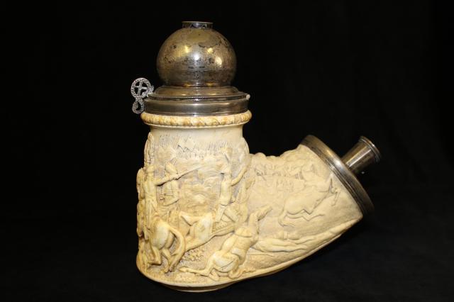 Pipe made of bone with metal top and carved with a battle scene