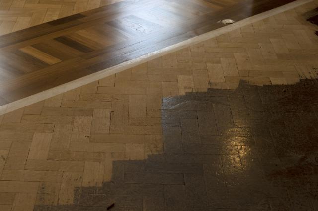 Detail showing warm hardwood banding and partly sanded floor