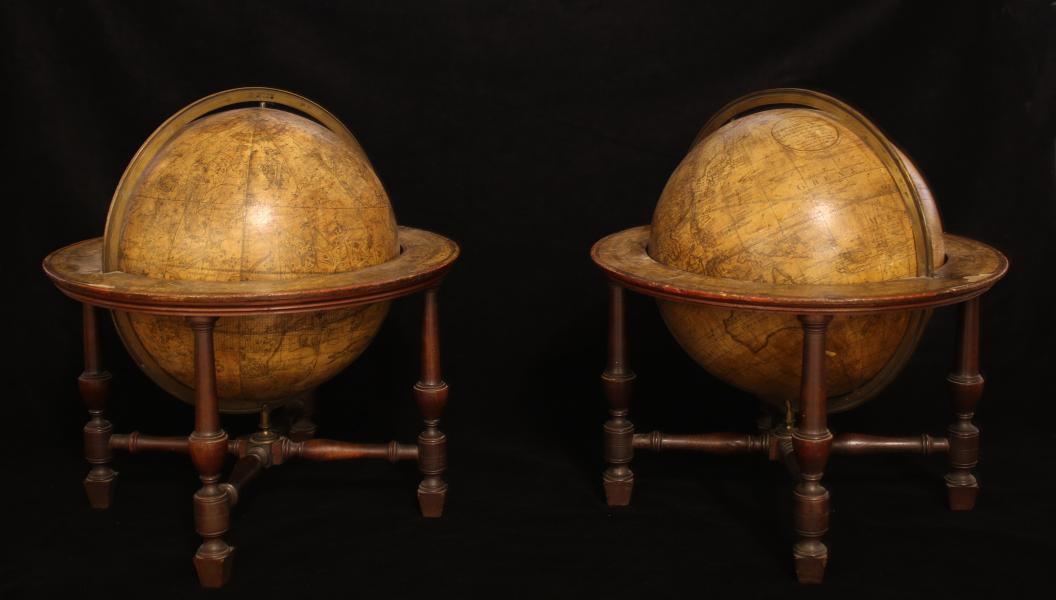 A pair of globes on mahogany stands