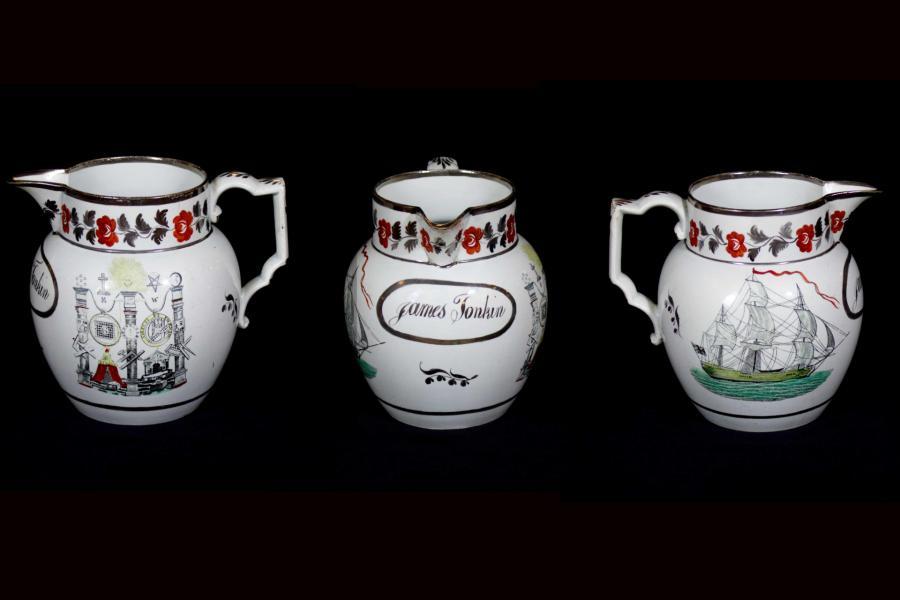 White jug decorated with a print of a ship on one side and a mix of Royal Arch and Knights Templar emblems on the other