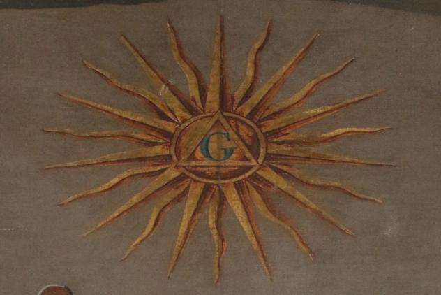 Yellow sun with a triangle and blue letter G in the centre